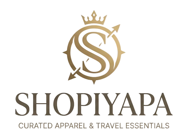 A logo-style graphic on a warm beige textured background featuring a large stylized golden 'S' emblem with a crown and arrows, above the text 'SHOPIYAPA' and smaller text 'CURATED APPAREL & TRAVEL ESSENTIALS'